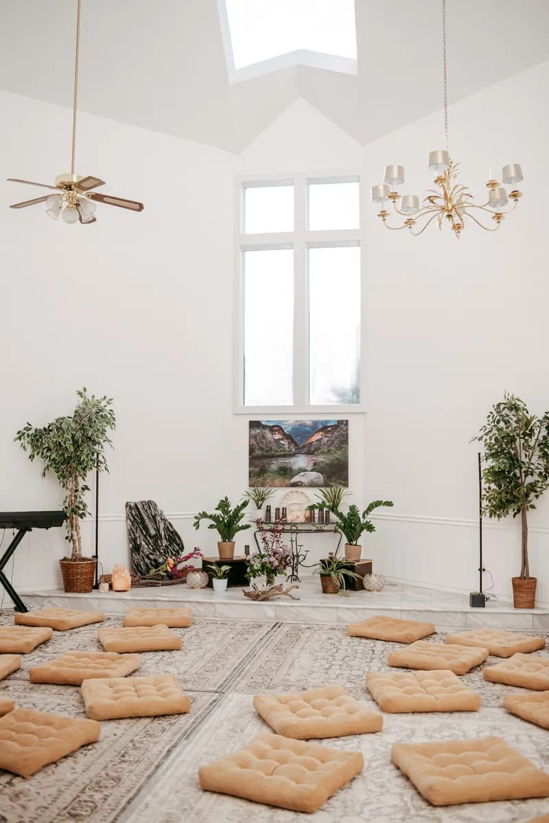 Sunlit ceremony room with meditation cushions arranged in circle